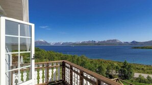 Un balcón con vistas a un lago y montañas.