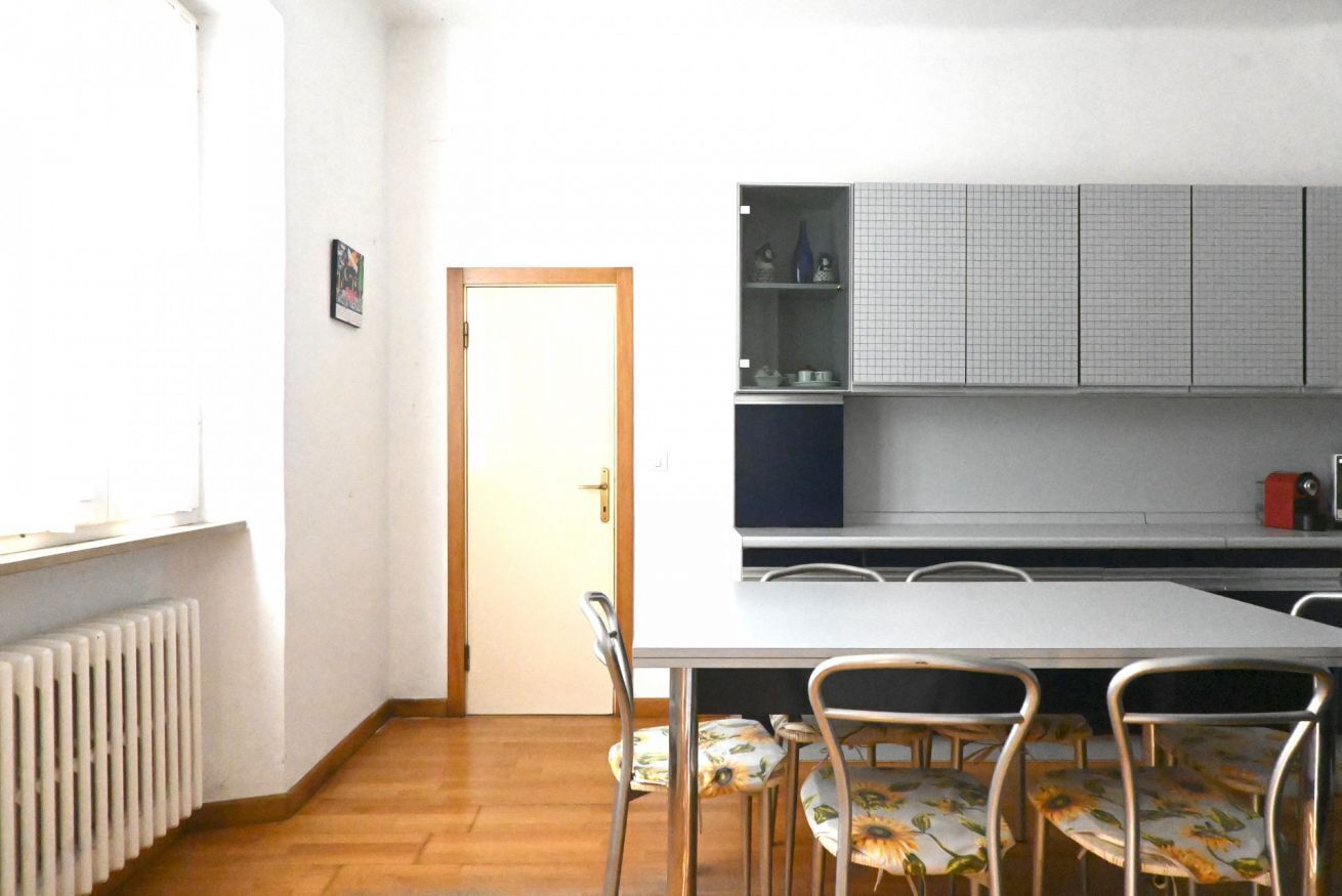 Una cocina con encimera blanca, horno empotrado y ventana.