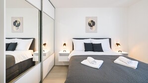 A modern hotel room with a large bed, bedside tables, wall art, and a mirror. - Villa IviCasa with pool (Murvica)