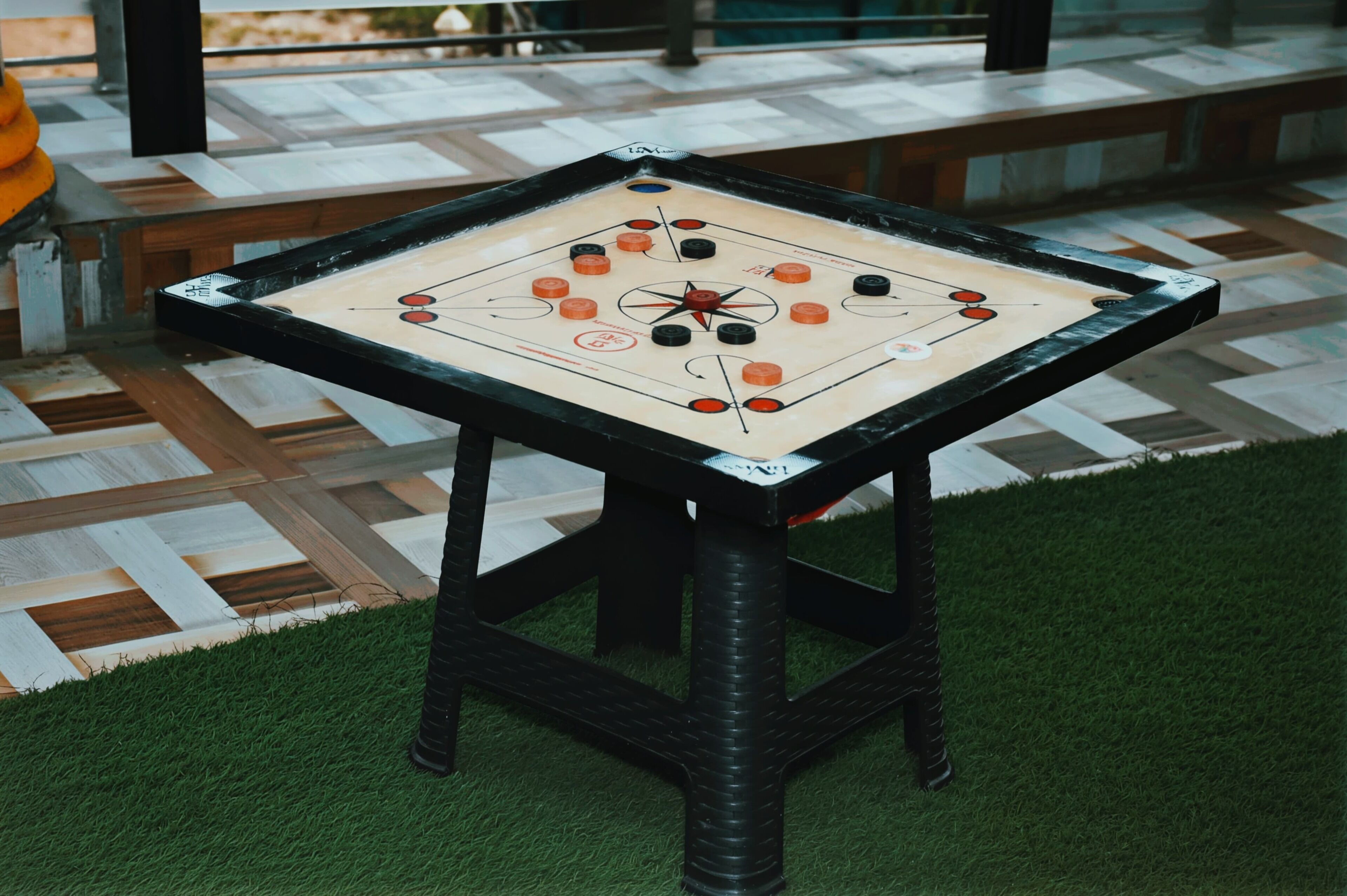 Une table dont le plateau présente un motif à carreaux et un dessin en forme d’étoile au centre.