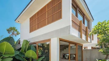 A modern two-story house with a swimming pool, large windows, and a balcony.