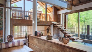 Un interior de madera con una escalera, un banco y una estatua.