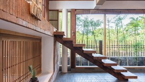 Una escalera de madera con vistas al bambú exterior.