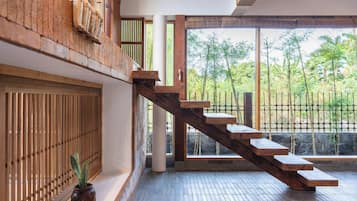 Una escalera de madera con vistas al bambú exterior.