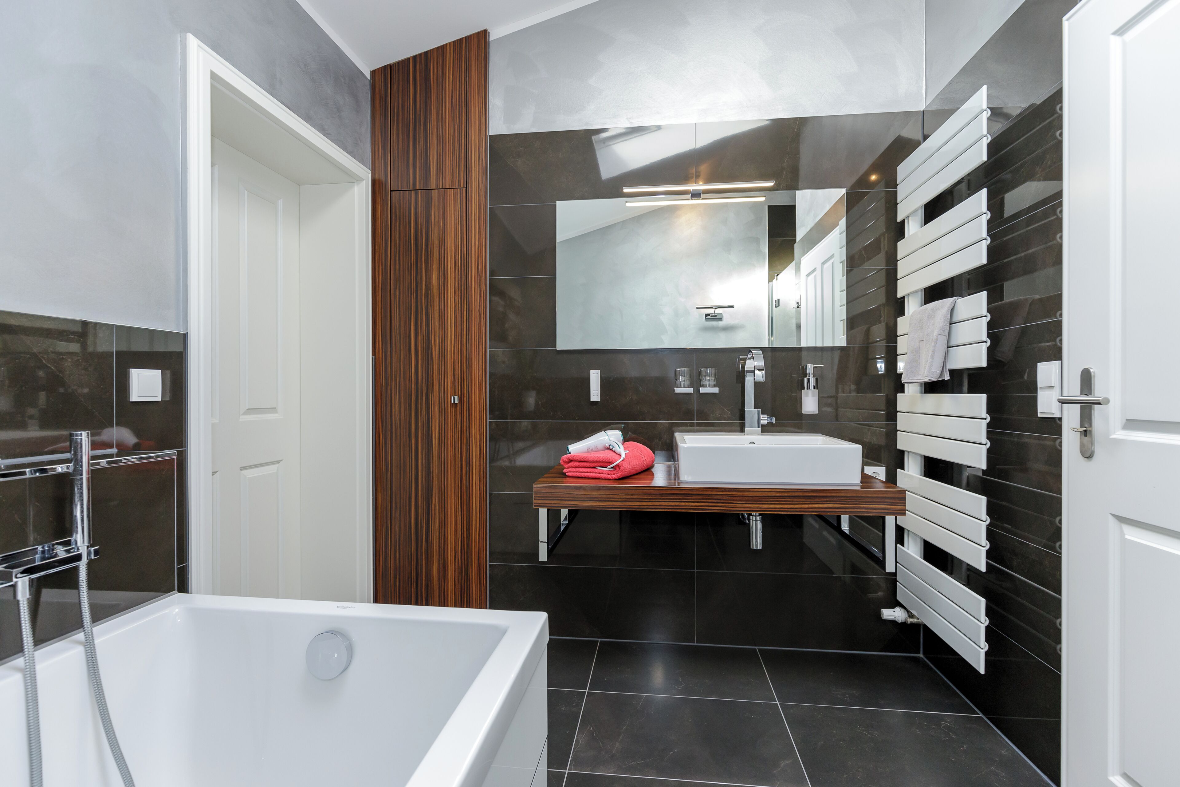 Ein modernes Badezimmer mit Badewanne, Waschbecken und Spiegel.