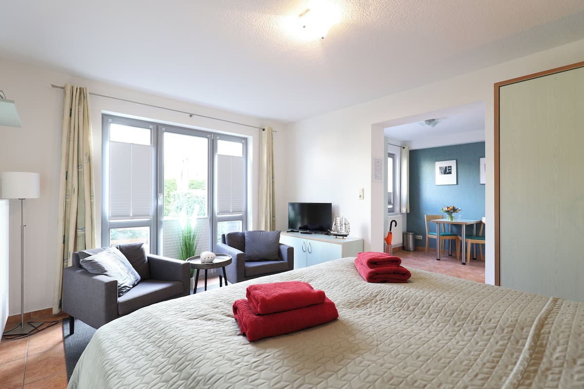 Une chambre d’hôtel comprenant un lit, un bureau, une télévision et un coin repas.
