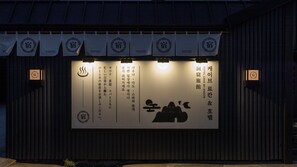A building facade with multiple signs, including a prominent one with Korean text and a logo.