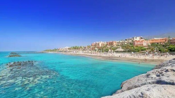 A coastal town with a beach, clear turquoise waters, and buildings along the shore. - Villa Zen Adeje - Private Heated Pool (Adeje)