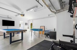 A recreational room with a pool table, foosball table, and exercise equipment. - AcquaVista (Terrigal)