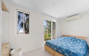 A bedroom with a bed, a window, and an air conditioning unit. - AcquaVista (Terrigal)