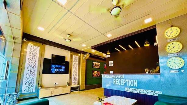 Un área de recepción con mostrador, relojes y asientos.