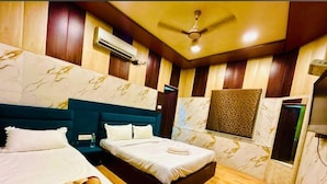 Habitación de hotel con dos camas, ventilador de techo, aire acondicionado y papel tapiz estampado.