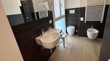 Driepersoonskamer | Badkamer | Een douche, gratis toiletartikelen, een haardroger, handdoeken
