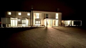 A building with a central entrance, multiple windows, and a paved driveway. - HOTEL VILLA MARY (Santa Maria di Sala)
