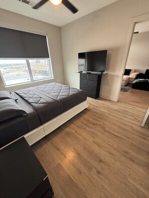 A bedroom with a bed, a TV, a window, and a door. - Cozy contemporary & chic Deep Ellum apartment in Dallas’s nightlife district (Dallas)