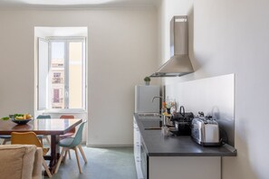 A modern kitchen with a dining area, a window, and a view of buildings outside. - iFlat | Calm & Spacious Urban Oasis Fons Trevi B13 (Rome)
