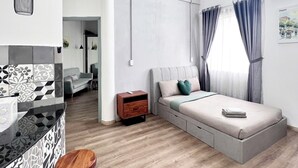 Een moderne slaapkamer met een bed, nachtkastje en een klein houten krukje.