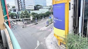Stadsgezicht met moderne gebouwen, een opvallend geel en blauw bord voor KKV, en een zebrapad.