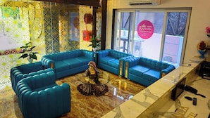 Un'area reception con un divano blu, una statua decorativa e un cartello che indica che l'hotel è una location per matrimoni.