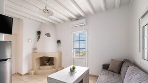 Una cocina moderna con horno integrado, una mesa de comedor, un sofá, un televisor y una chimenea.
