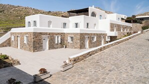 Un edificio moderno con fachada de piedra, múltiples ventanas y techo inclinado.