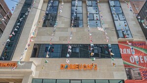 A hotel with a modern facade, multiple windows, and a visible cafe sign. - DEUMEU HOTEL (Changwon)