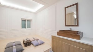 A modern bathroom with a skylight, a wooden vanity, and a large mirror. - DEUMEU HOTEL (Changwon)