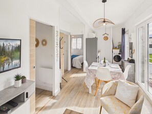 Un intérieur moderne comprenant un coin repas, un lit et une vue sur l’extérieur.