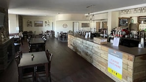 Un restaurante con barra, mesas y sillas de madera.