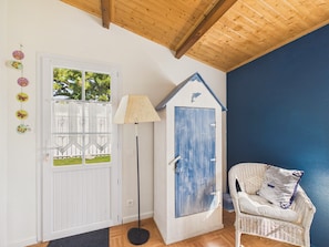 A room with a white door, a blue door, a wicker chair, and a floor lamp. - Holiday for 8 with pool, sea ​​300 m away (Barbâtre)