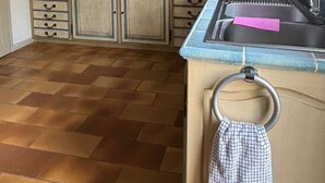 A kitchen with a microwave, oven, and sink. There are cabinets, a tiled backsplash, and a wooden shelf above the counter. - Villa BOUGAINVILLEA, magnificent villa on the heights of Vence. (Vence)