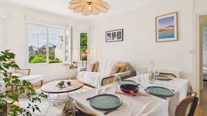 Ein Essbereich mit Tisch für zwei Personen, einer Couch und Blick auf den Garten.