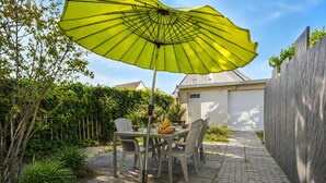 A patio with a table, chairs, and a yellow umbrella. - Family home: beach walk, garden & BBQ (Le Pouliguen)