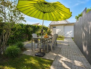 A patio with a table, chairs, and a yellow umbrella. - Family home: beach walk, garden & BBQ (Le Pouliguen)