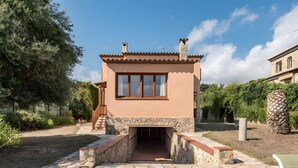 A small, single-story building with a stone facade, a wooden staircase, and a clear sky. - Residencia occitania-building complex with 5 apartments (Calonge)