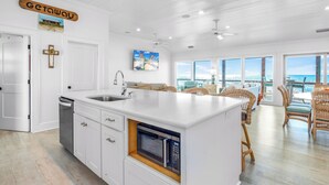 A modern kitchen with a built-in microwave, white cabinetry, and a large island. - Getaway Beach Front, St. George Island Private 4  Bedroom Home (St. George Island)