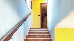 A staircase with a handrail, leading to a door at the top. - Palazzo Peisoire - Appartamento con garage per E-Bike (Montaldo Torinese)