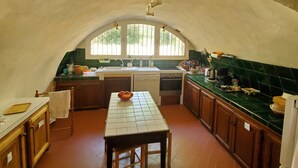 An arched kitchen with a tiled backsplash, wooden cabinets, a central island, and a window providing natural light. - Rent house very beautiful mas provençal south Luberon - 10 beds (Mérindol)