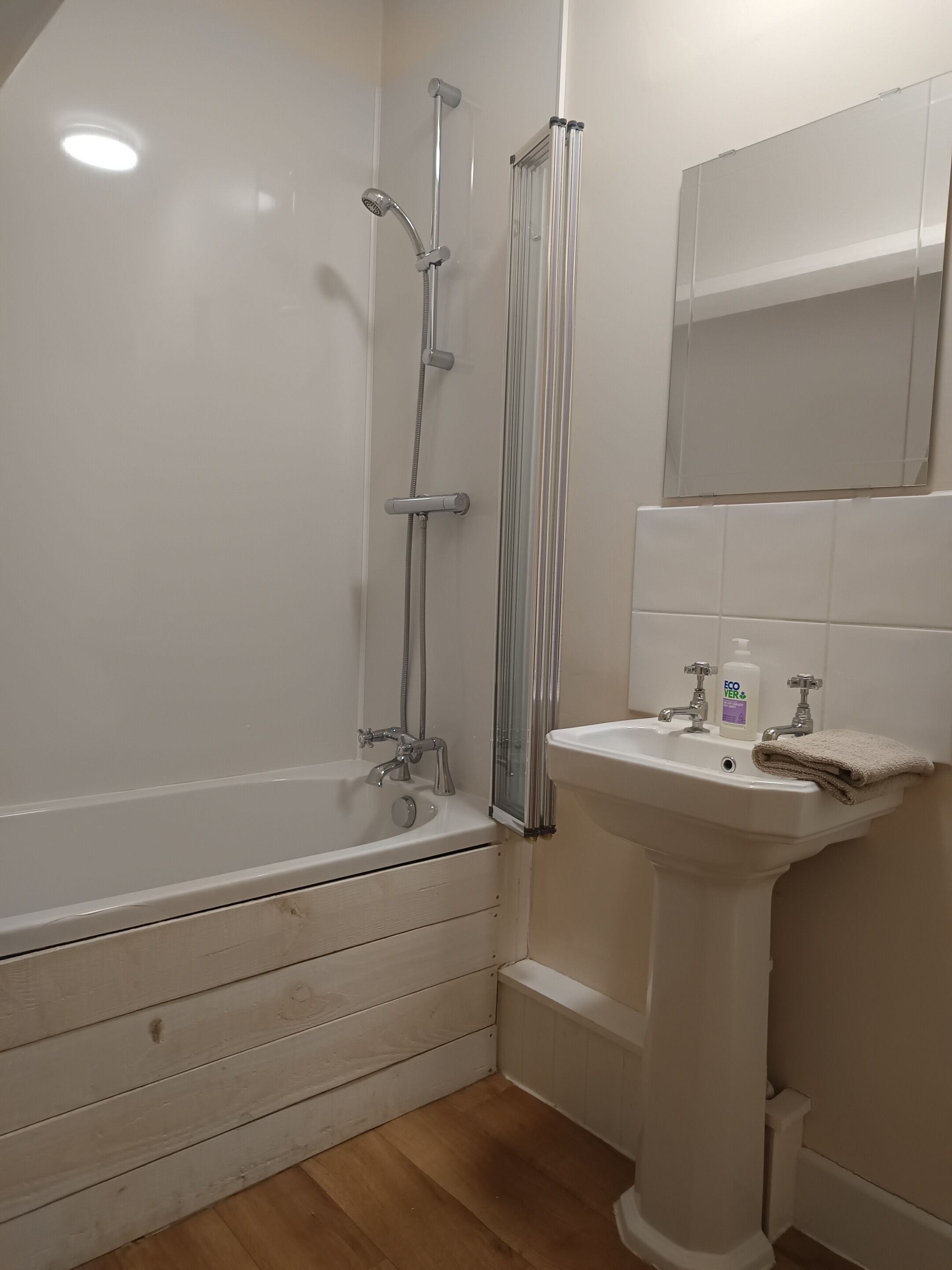 A bathroom with a bathtub, shower, and sink.