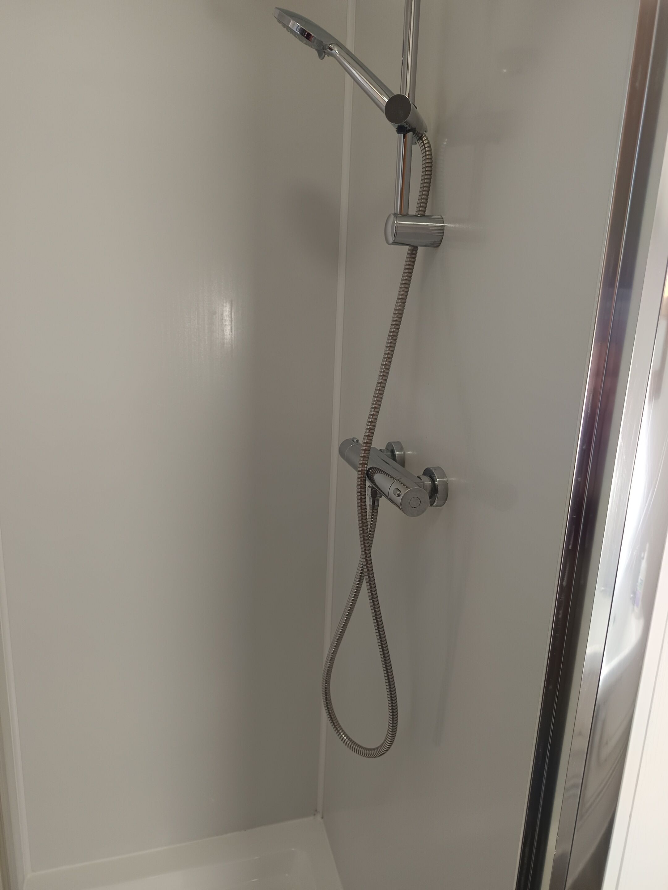 A shower with a handheld showerhead and a flexible hose.