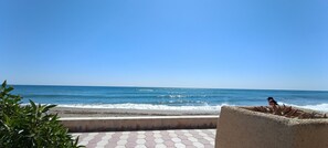 A beach view with a clear sky, a sandy area, and a paved walkway. - Beachfront Flat With Spectacular sea Views (Roquetas de Mar)