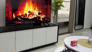 Ein modernes Wohnzimmer mit Kamin, einem Bett, einem Spiegel und einem Schachbrett.