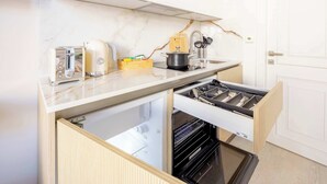 Eine kleine Küche mit Backofen, Toaster, Wasserkocher und Spüle.