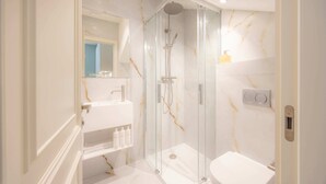 A bathroom with a glass-enclosed shower, a white sink, and a toilet. - Premium Studio 15 at The Orange Door Little Venice (Greater London)