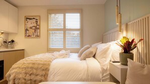 A bedroom with a bed, bedside table, and a window with blinds. - Standard Studio 6 at The Orange Door Little Venice (Greater London)