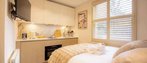 1 habitación, escritorio, tabla de planchar con plancha y cuna de viaje
