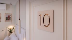 Eine Wand mit einem Nummernschild '10' und einer Pendelleuchte.