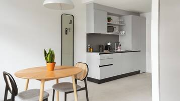 A modern kitchen with a microwave, coffee maker, and cabinets.
