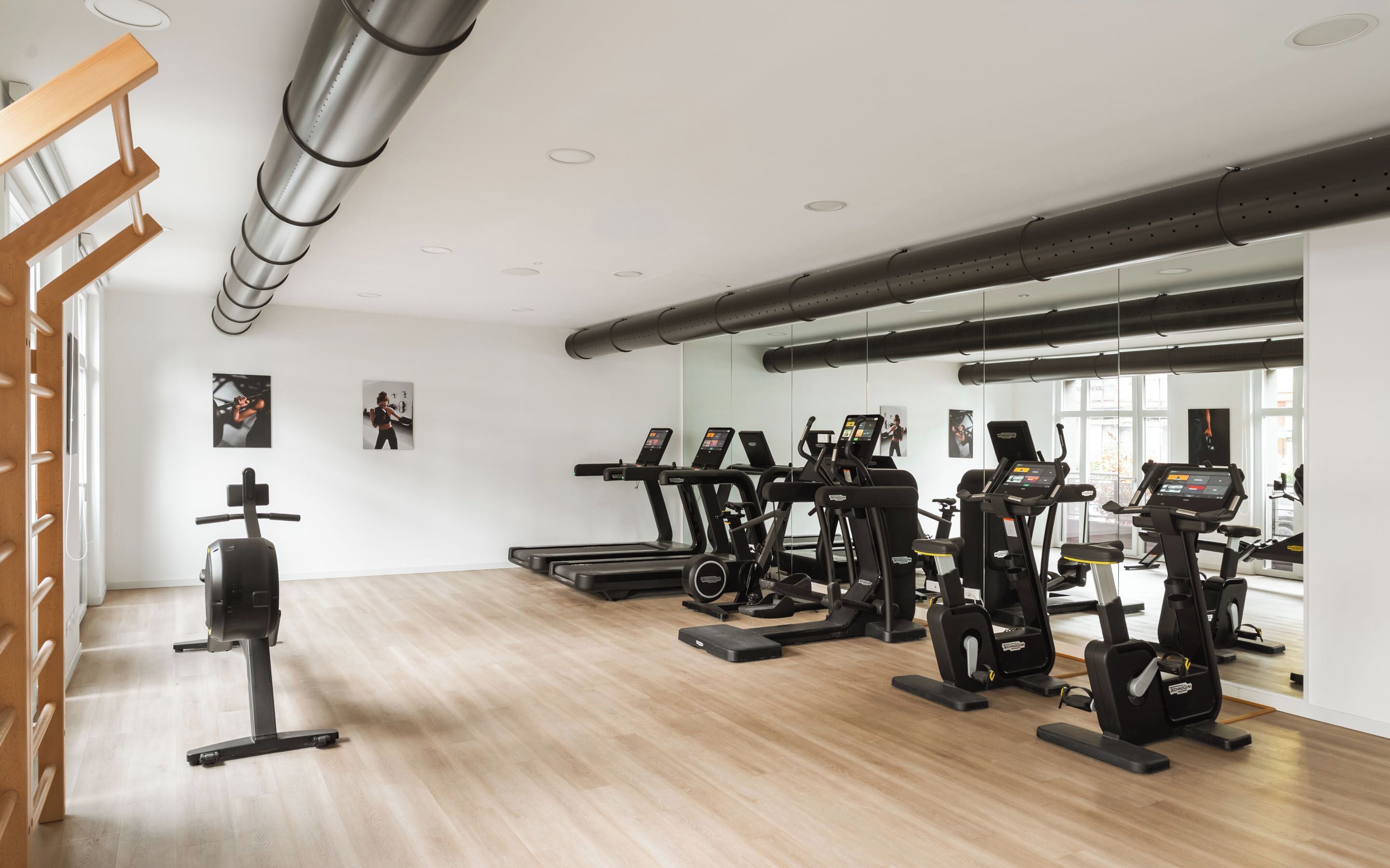 Un gimnasio con cintas de correr, elípticas y una bicicleta estática.