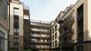 A multi-story residential building with balconies, a central courtyard, and a modern architectural design. - Limehome Milan Navigli (Milan)